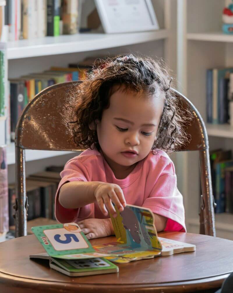 little girl looking at books