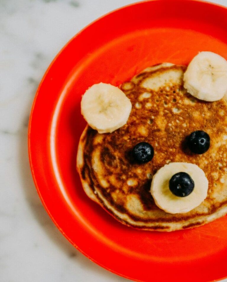 Pancake with bananas and blueberries. Looks like a cute animal face.