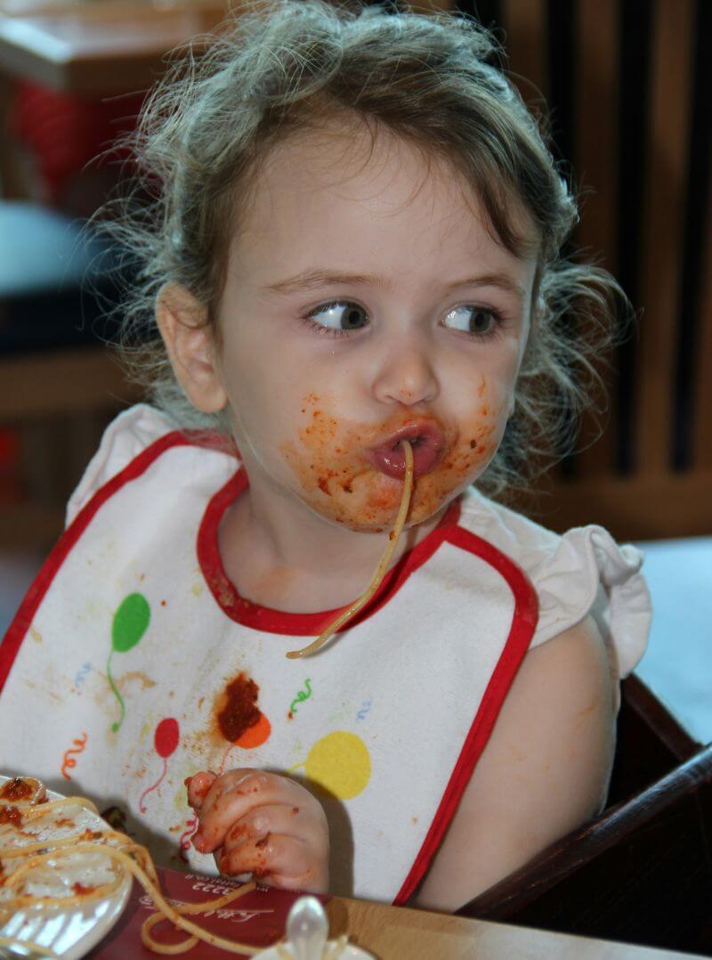 Toddler eating spaghetti.